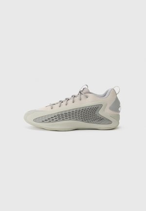 Basket basse gris clair avec tige en mesh, panneau latéral à motif alvéolé, fermeture à lacets et languette au talon sur fond uni.