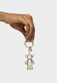 Metal bear keychain with shiny silver finish, featuring round ears and a chunky body shape, attached to a circular keyring.