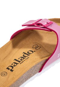 Rosa slide-sandal med spänne, korkfotbädd och vit gummisula. Har en texturerad innersula med varumärkeslogotyp. Designad för komfort.