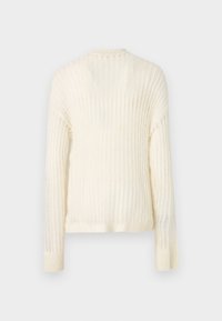 Cremfarbener gerippter Pullover mit langen Ärmeln, einem runden Halsausschnitt und einer strukturierten Oberfläche. Auf der Rückseite sind horizontale Rippdetails vorhanden.