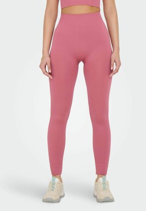 Roze geribbelde leggings met een hoge taille, slanke pasvorm en textuurstof. Gecombineerd met lichtgekleurde sportschoenen.