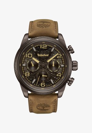 Brūns ādas siksna ar iegravētu logo, tumša metāla korpuss, strukturēts melns ciparnīca, zelta akcenti, lieli cipari un vairāki hronogrāfa apakšdiali.