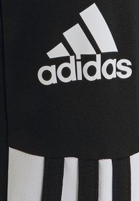 Zwarte sportstof met het witte Adidas-logo, met drie witte strepen die verticaal op een zwarte achtergrond lopen. Geverfde afwerking.