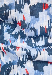 Multicolored fabric with an abstract pattern featuring navy blue, light blue, and red shapes. Smooth texture with a lightweight appearance.
