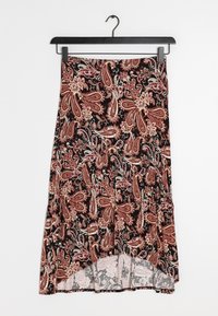 Mustat hameet, joissa on punaisia ja beigejä paisley-kuvioita, roikkuvat mustassa vaateripustimessa valkoista taustaa vasten.