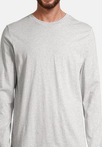Chemise à manches longues grise en mélange de coton. Présente un col rond, une texture douce et une coupe décontractée, idéale pour un usage quotidien.