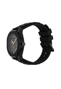 Montre en caoutchouc noir avec un boîtier carré, un bracelet texturé et des accents dorés sur un cadran noir, avec des sous-cadrans ronds et un détail de logo.