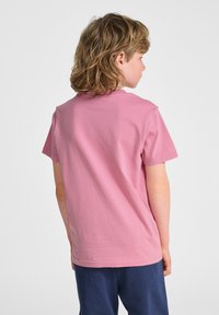 Lyserød T-shirt med korte ærmer lavet af bomuld, med rund hals og en afslappet pasform. Bagsiden har en glat tekstur uden mønstre.