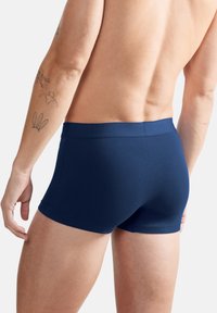 Marineblaue Boxershorts aus einem glatten, elastischen Stoff. Mit einem weichen Bund und einer enganliegenden Passform für hohen Tragekomfort.