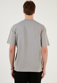 Grå bomulds T-shirt med korte ærmer, rund halsudskæring og afslappet pasform. Glat tekstur, ensfarvet design, og ingen synlige mønstre eller accenter.