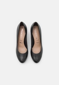 Escarpins noirs en cuir avec un bout arrondi, texture lisse et doublure intérieure beige, avec des marquages argentés et mention de la taille.
