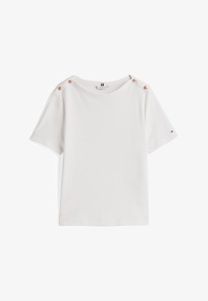 T-shirt blanc à manches courtes en coton doux. Présente un col bateau et trois boutons décoratifs sur l'épaule gauche. Design minimaliste.