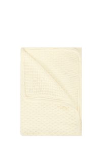 Koc bawełniany w kolorze kremowym z teksturowanym, tkanym wzorem i solidnym brzegiem. Wzór prezentuje złożony róg, ukazując tylną stronę.