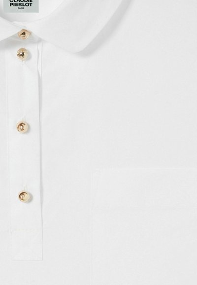 Camisa blanca de cuello hecho de una tela suave, con botones dorados y un bolsillo en el pecho izquierdo. Diseño simple y clásico con un mínimo de detalles.