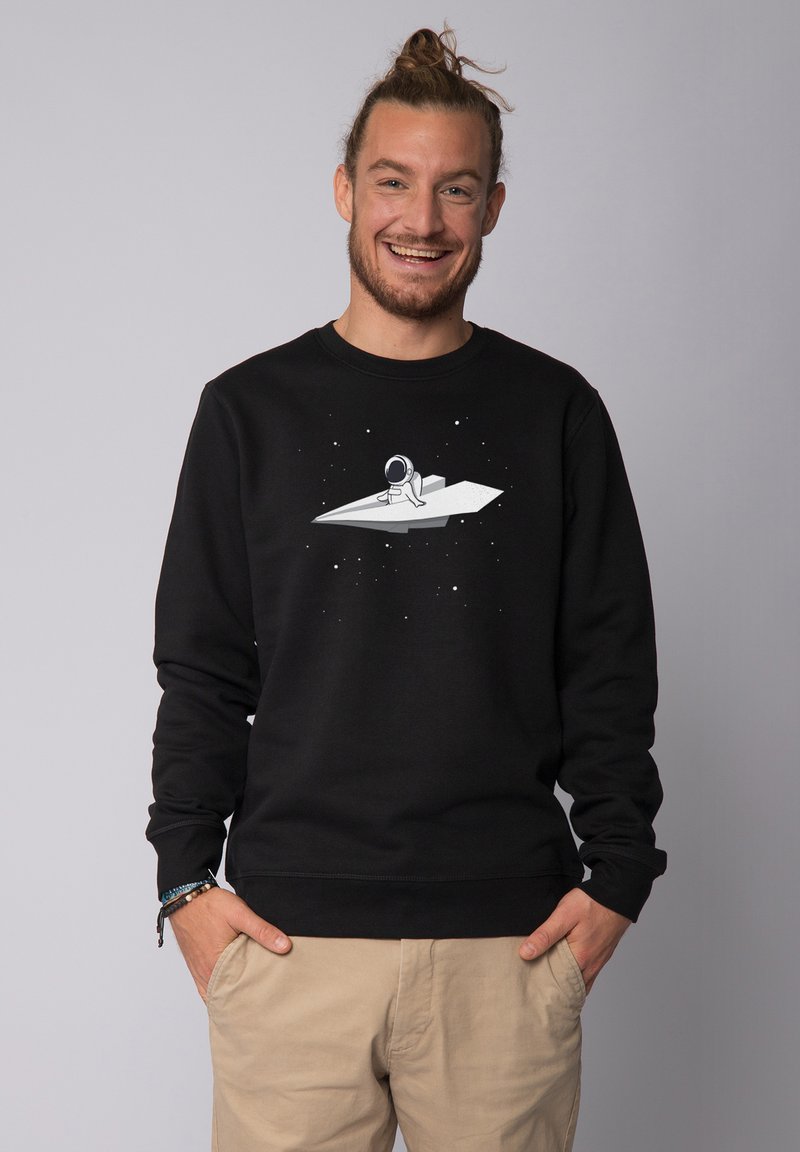 Black sweatshirt featuring a central graphic of an astronaut on a paper plane against a starry background. Ribbed cuffs and hem.