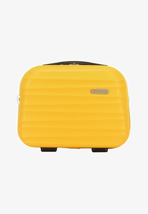 Žlutý tvrdý kufr s rýhovaným povrchem, černými akcenty, horní rukojetí a dvěma kolečky. Na přední straně se nachází destička s logem značky.