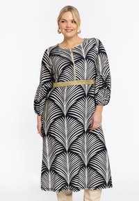 Schwarz-weiß gemustertes Kleid mit Palmenblattdesign, Puffärmeln, einem goldenen Gürtel und einem runden Ausschnitt mit einem dekorativen Reißverschluss.
