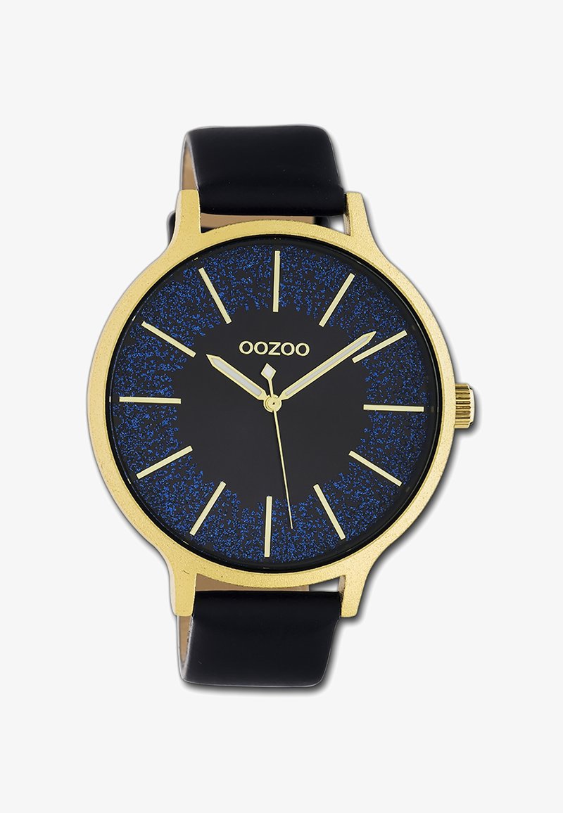 Montre ronde de couleur or avec un cadran noir ornés de taches bleues. Bracelet en cuir noir. Index et aiguilles dorés, aiguille des secondes en forme de diamant.