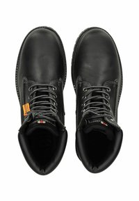 Botas de cuero negro con punta redonda, cordones grises, un collar acolchado y costuras reforzadas. Presentan una etiqueta naranja en el lateral.