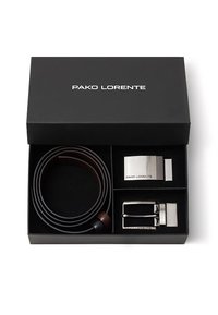 Czarny zestaw prezentowy z brązowym skórzanym paskiem, srebrną metalową klamrą oraz prostokątnym metalowym elementem z wygrawerowanym napisem "PAKO LORENTE". Teksturowane wnętrze.