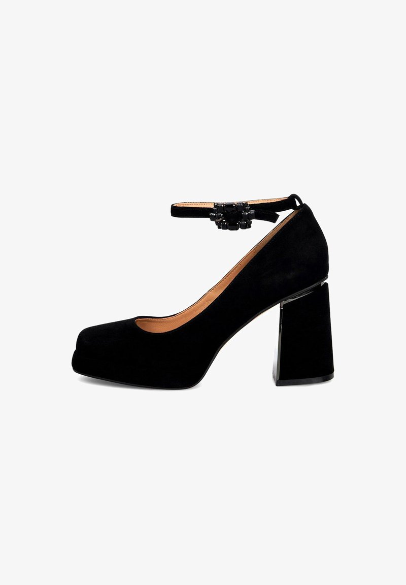 Tacchi a piattaforma in suede nero con un tacco a blocco chunky e cinturino alla caviglia, adornati con un accento decorativo in perline sul cinturino.