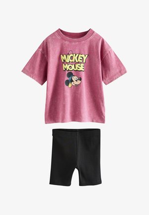 Różowy t-shirt z krótkim rękawem z Myszką Miki i żółtymi napisami, w połączeniu z prostymi czarnymi szortami do kolan.