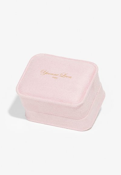Cutie rectangulară de depozitare roz, cu un exterior moale și texturat. Are inscripționat în aur textul "Yvonne Leon PARIS" pe capac. Colțuri rotunjite.