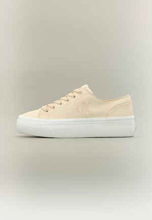 Beežikas lõuendist madala varrega toss valge paksu kummipõhjaga ja tagasihoidliku "CK" logoga küljel.