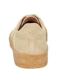 Chaussure en suède beige avec une semelle en caoutchouc texturé de couleur brun clair. Présente un design simple et un logo en relief au niveau du talon.