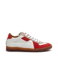 White leather sneaker with red suede accents, beige tongue, and rubber sole. Features traditional laces and diamond-shaped side design.