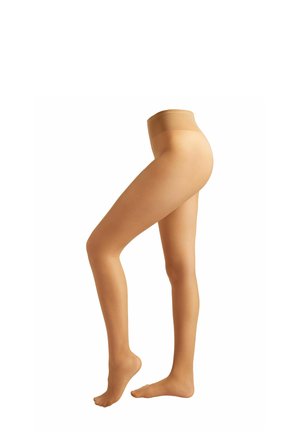 Female legs wearing nude sheer pantyhose, one leg raised on toes, shown from waist to feet on white background.