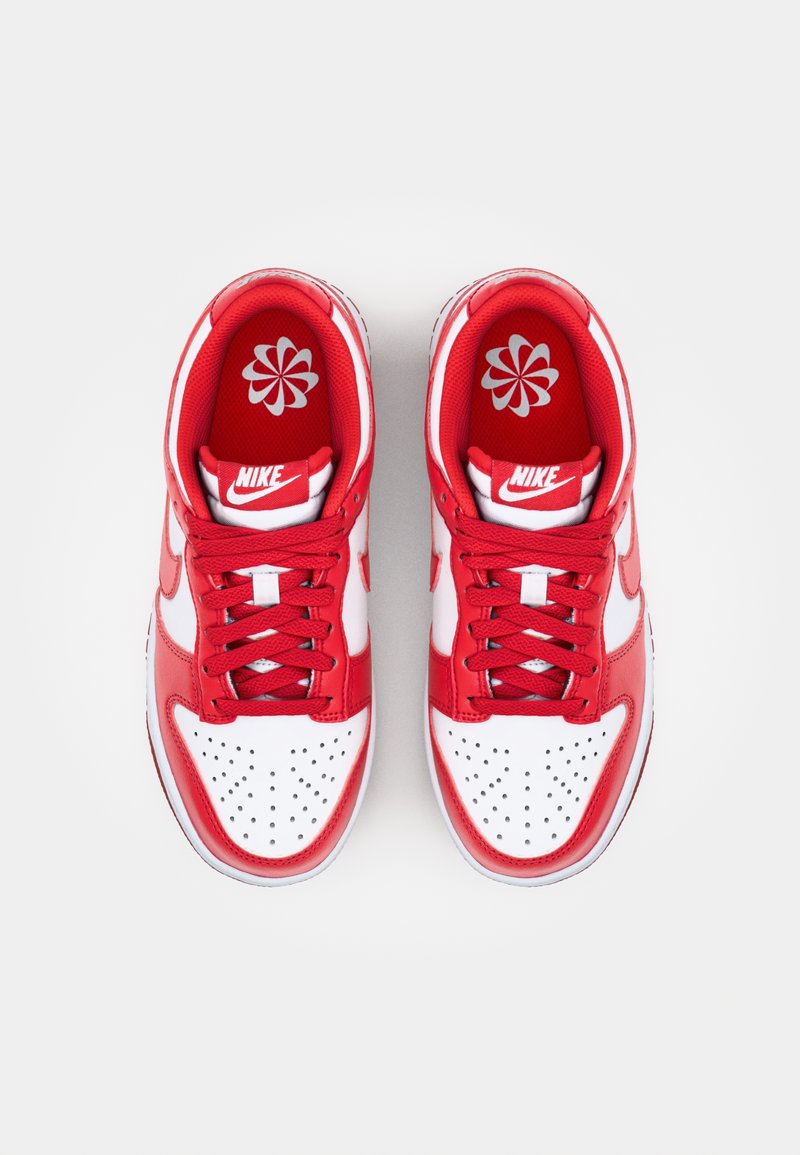 Baskets Nike rouges et blanches avec une tige en cuir, un bout perforé et des lacets rouges. Logo sur la languette et motif floral sur les semelles intérieures.