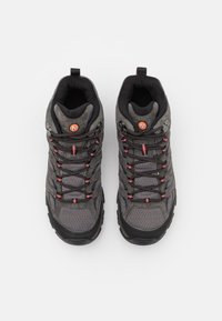 Szare buty trekkingowe z cholewką z siateczki i zamszu, czarną gumową podeszwą, czerwonymi akcentami w sznurówkach oraz okrągłym logo na języku.
