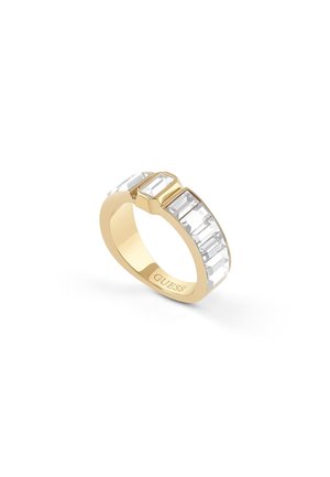Bague en or avec des pierres claires rectangulaires le long du bandeau, avec le nom de la marque Guess gravé à l'intérieur.