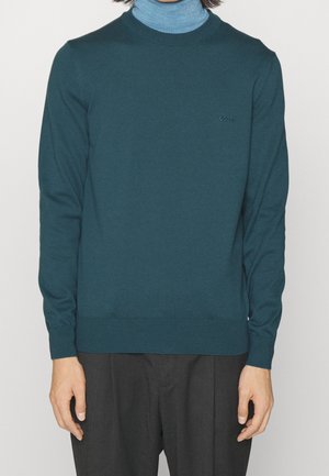 Dunkelblauer Strickpullover mit langen Ärmeln, Rundhalsausschnitt, gerippten Bündchen und Saum, mit einem kleinen Logo auf der Brust.
