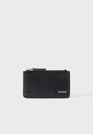 Čierny kožený držiak na karty s vrchným zipsom a zlatým logom "HUGO" v pravom dolnom rohu, na jednoduchom svetlom pozadí.