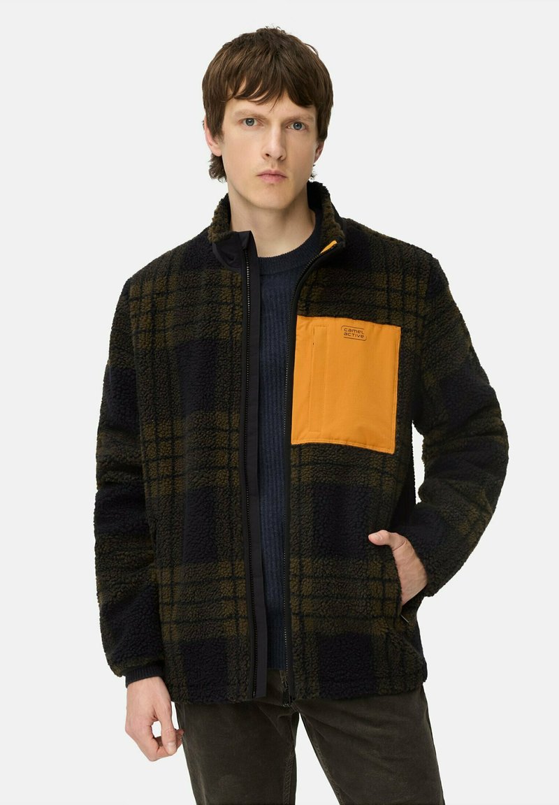 Fleecejacke mit einem schwarz-grünen Karomuster, ausgestatt mit einer orangen Brusttasche, einem kontrastierenden Reißverschluss und einem Stehkragen-Design.