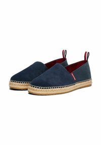 Scarpe slip-on in suede blu navy con retro in tela, suola in juta e linguette in rosso e blu navy. Presentano una fodera interna rossa a contrasto e bordi cuciti.
