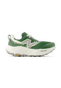 Chaussure de trail running verte et blanche avec une épaisse semelle blanche, semelle extérieure Vibram, lacets et un grand logo "N" sur le côté.