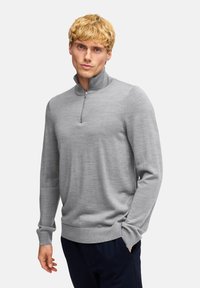 Grau melierter Halbzip-Pullover aus einem weichen Strickstoff mit langen Ärmeln und gerippten Bündchen. Verfügt über einen Stehkragen und einen geraden Saum.