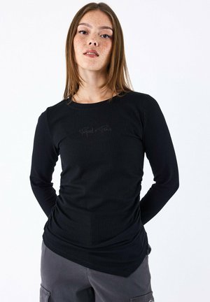 Maglia nera a maniche lunghe a coste con scollo rotondo, caratterizzata da una discreta ricamatura "Project x Paris" sul davanti.