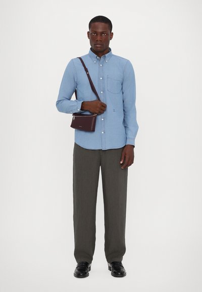 Light blue button-up shirt with long sleeves, single pocket, gray linen pants, and a small dark purple crossbody bag, worn with black shoes.