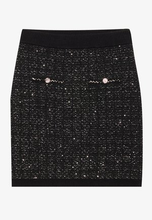 Gonna nera in maglia con superficie testurizzata e elementi luccicanti, vita a coste e dettagli decorativi vicino alla parte superiore.