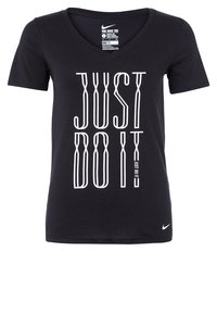 Camiseta de algodón negra con cuello en V, que presenta un destacado gráfico blanco "JUST DO IT" en una disposición vertical. Logo de Nike en la esquina inferior derecha.