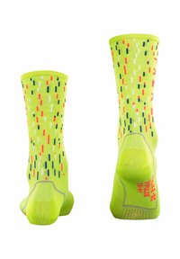 Helle gelbe Socken mit mehrfarbigen vertikalen Streifen, verstärkter Ferse und strukturiertem Muster für besseren Halt. Hergestellt aus einem dehnbaren Material.