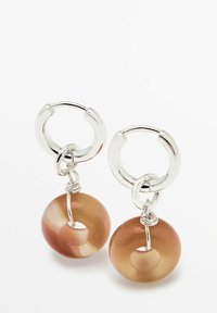 Gli orecchini a cerchio in argento presentano perline circolari traslucide di colore marrone con un foro centrale, accentuate da dettagli in filo d'argento.