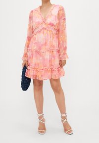 Roze bloemenjurk met geplooide lagen, lange mouwen en een V-hals. Heeft een lichtgewicht, doorschijnende stof en subtiele pastelaccenten.