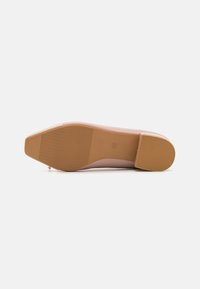 Chaussure plate rose avec un bout pointu, tige en cuir lisse et semelle en caoutchouc texturé. Présente un léger talon et des accents de design minimalistes.