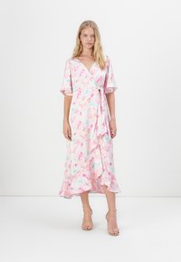 Ροζ και μπλε λουλουδένιο φόρεμα με φαρδιές κοντές μανίκες, βαθύ V-ντεκολτέ και ριχτό στρίφωμα. Ελαφρύ ύφασμα, μαλακή υφή, ρέουσα σιλουέτα.