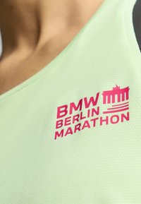 Svijetlozelena atletska majica bez rukava s teksturiranom površinom sadrži hrabar, ružičasti logo i dizajnerske elemente "BMW BERLIN MARATHON".